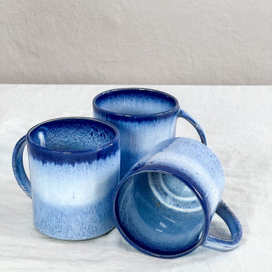3 Keramik Tassen mit Henkel auf dem Tisch in einem Tiefblauen farbverlauf