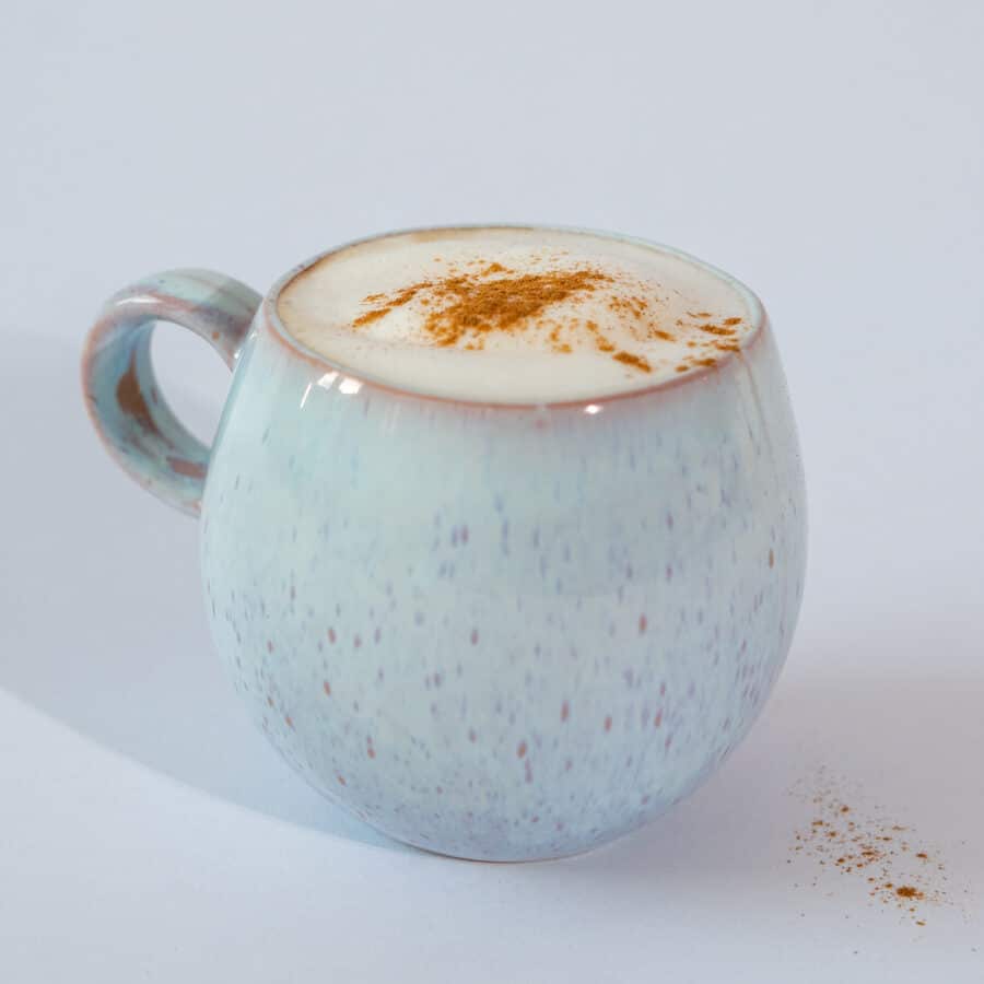 Blaue bauchige Keramik Tasse gefüllt mit leckerem Cappuccino